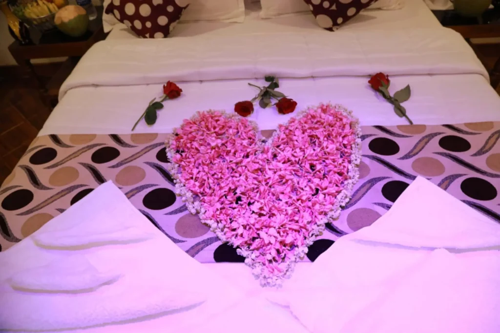 Rose petal heart decoration on a houseboat bed for an anniversary in Alleppey