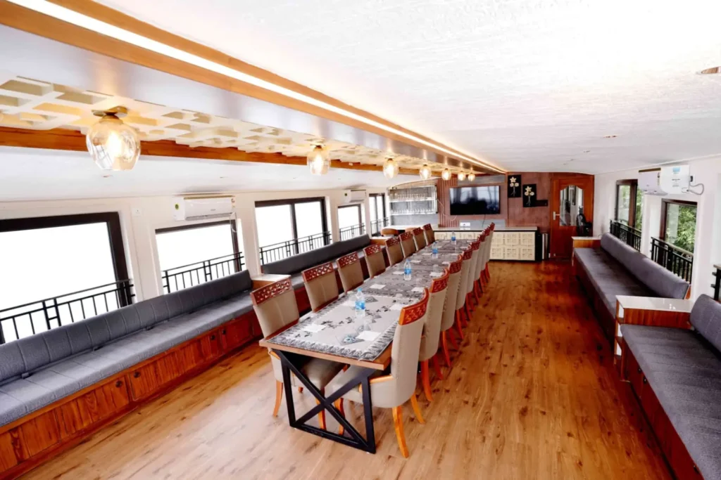 Family dining together inside a premium houseboat during an Alleppey backwater trip